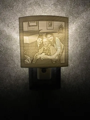 Photo shows an example of a lithopane nightlight illuminating a photo.