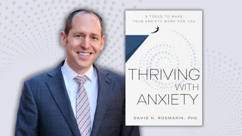 Dr. David H. Rosmarin smiling with an image of his book ,"Thriving with Anxiety", next to him.