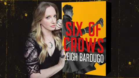 Leigh Bardugo holding a special redesigned copy of her book Six of Crows