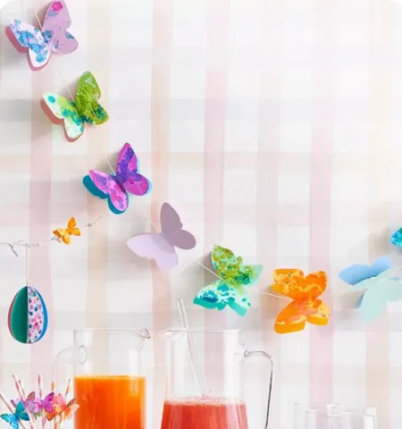 garland of 3D butterflies hanging on a wall above a table